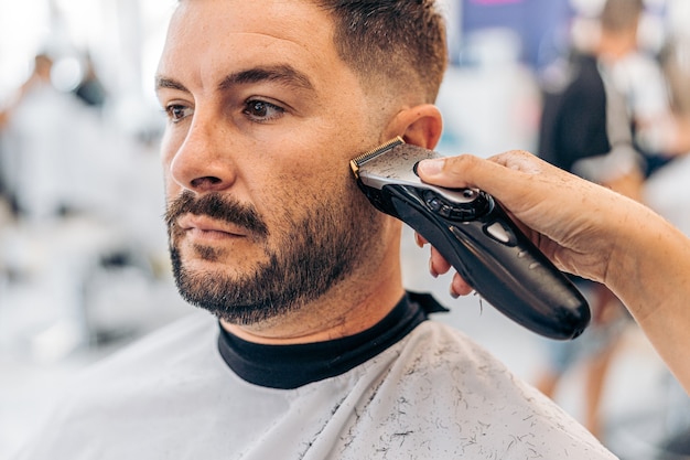 Portrait of a caucasian adult man being shaved ina barbershop