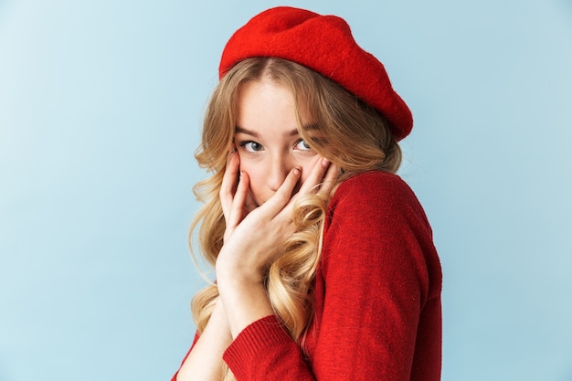 Portrait of caucasian blond woman 20s wearing red beret hiding and c