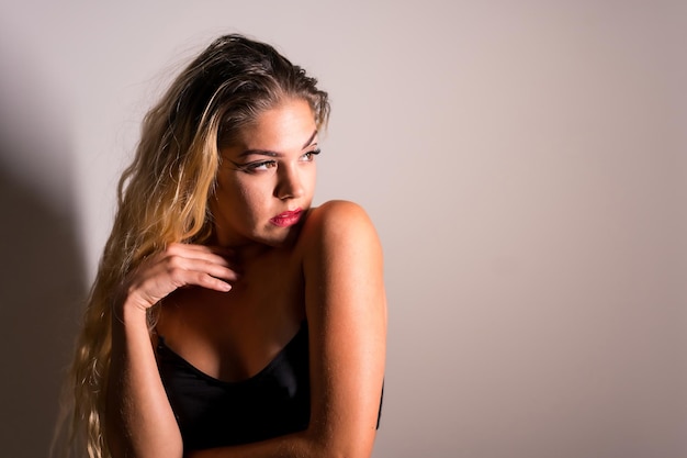 Portrait of a caucasian blonde girl with eye drawing makeup,\
groomed eyelashes on a white background with a set of studio\
shadows