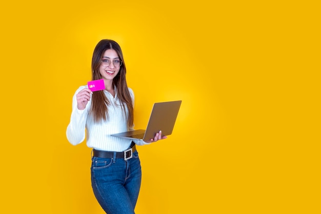 Portrait of caucasian girl holding credit card and laptop for remote banking Smiling pretty girl