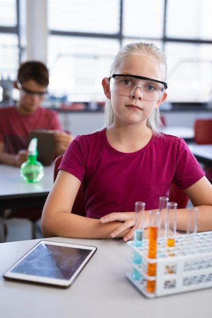 Portrait of caucasian girl wearing protective glasses in science class at laboratory