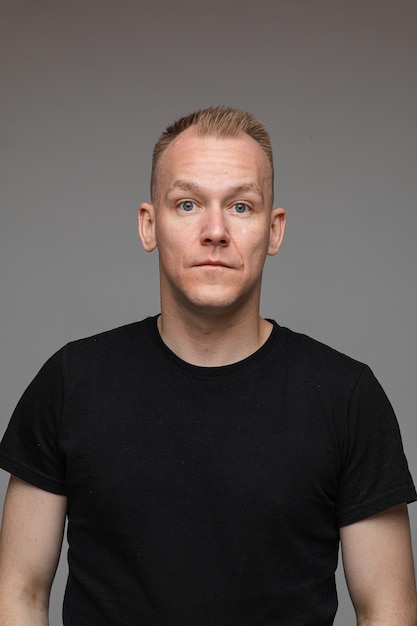 Portrait of caucasian man in black t-shirt looks to the camera and smiles 