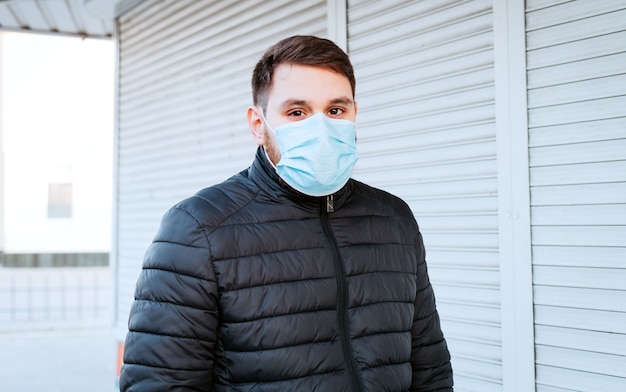 Ritratto di uomo caucasico in maschera igienica facciale, maschera di protezione respiratoria all'aperto