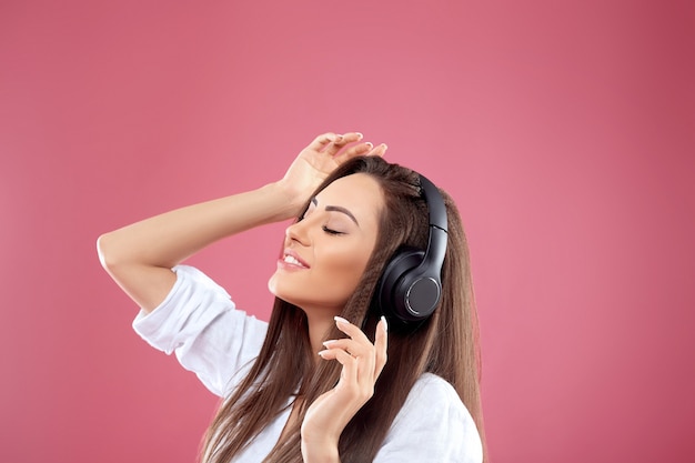 Portrait of caucasian pretty woman listening to music using wireless headphones