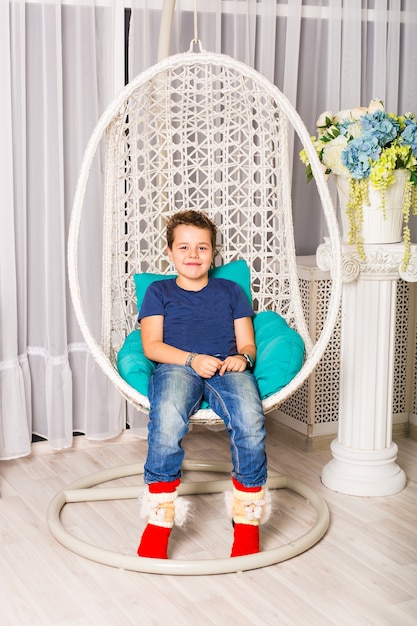 Portrait of Caucasian smiling laughing baby boy sitting in chair looking directly in camera.