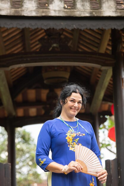 Photo portrait of caucasian woman in ao dai on the wooden bridge