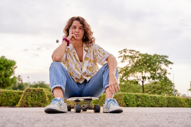 portrait of a Caucasian woman sitting on her skateboard