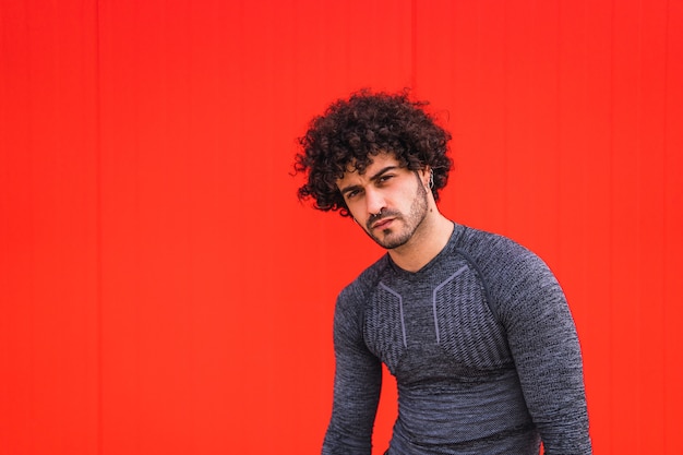 Portrait of a Caucasian young male against a red wall