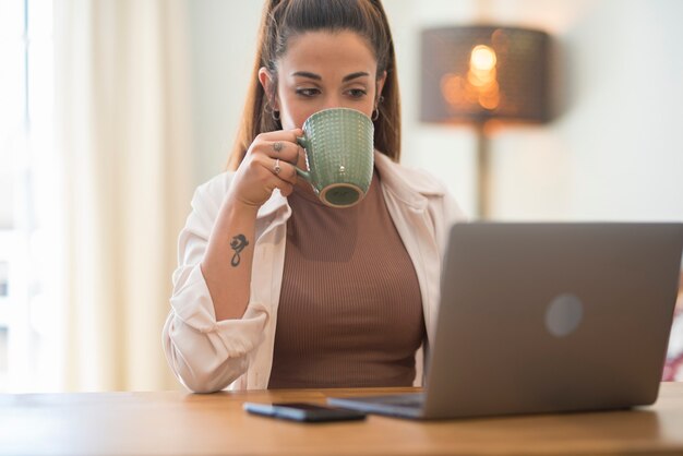 Portrait of caucasian young Woman working and typing on laptop computer keyboard - office and smart working job concept for professional business or employee corporate company