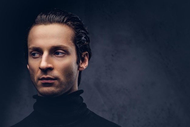 Portrait of a charismatic sensual male in black sweater with wet