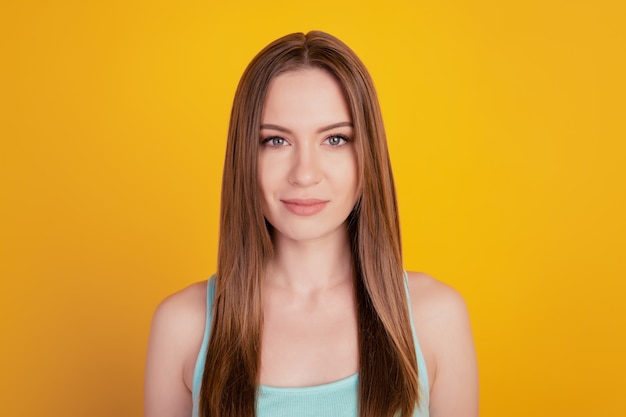 Portrait of charming adorable sweet young lady look camera on yellow background