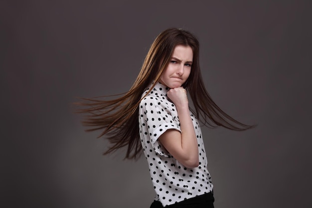 Portrait of a charming brunette little girl isolated on brown background