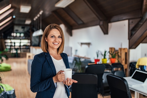 Photo portrait of charming businesswoman holding a mug.