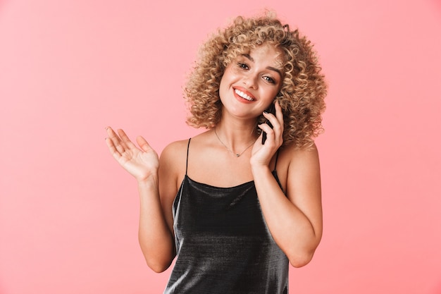 Portrait of charming curly woman 20s smiling and talking on mobile phone