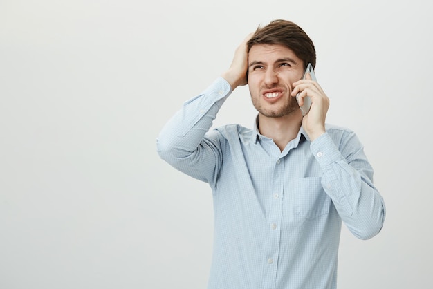 Portrait of charming european male coning mouth with hands