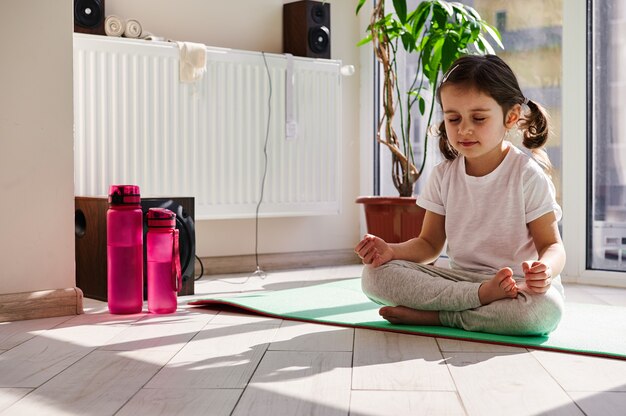 Portrait of a charming little girl during meditation and yoga practice