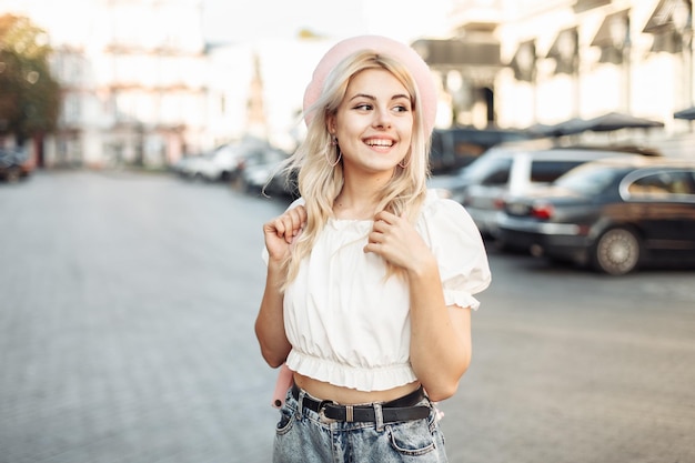 Portrait of a charming smiling girl in a beret in a European city Young having fun laughing woman in trendy outfit Lifestyle