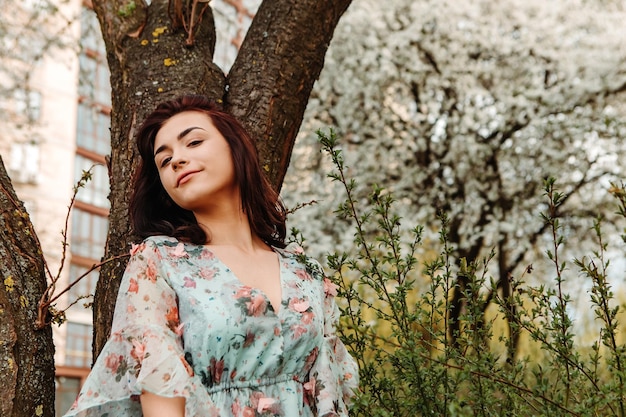 Photo portrait of charming woman posing near apple cherry tree blossoms blooming flowers in the garden