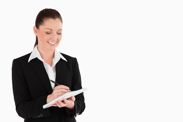 Ritratto di una donna affascinante in tuta di scrittura su un notebook