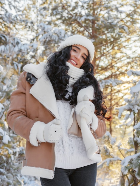 Portrait of charming young woman in fabulous winter forest