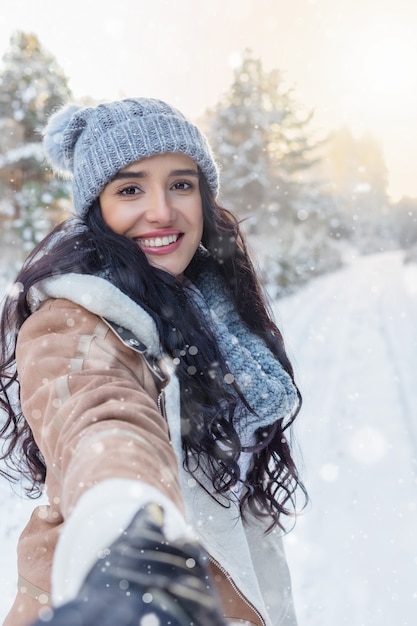 Portrait of charming young woman in fabulous winter forest