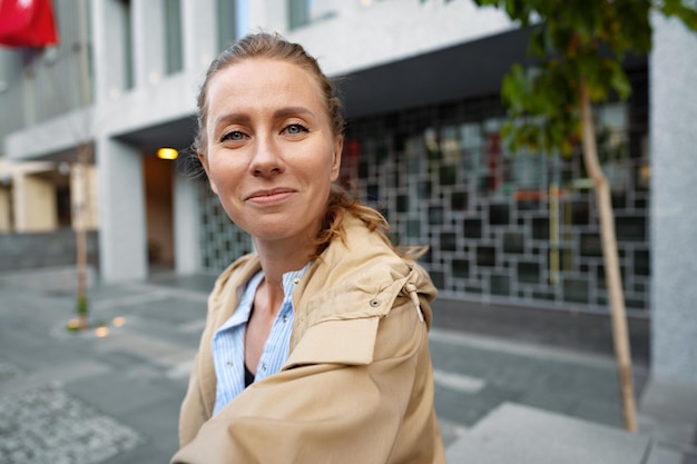 街でカメラにポーズをとる魅力的な若い女性のポートレート