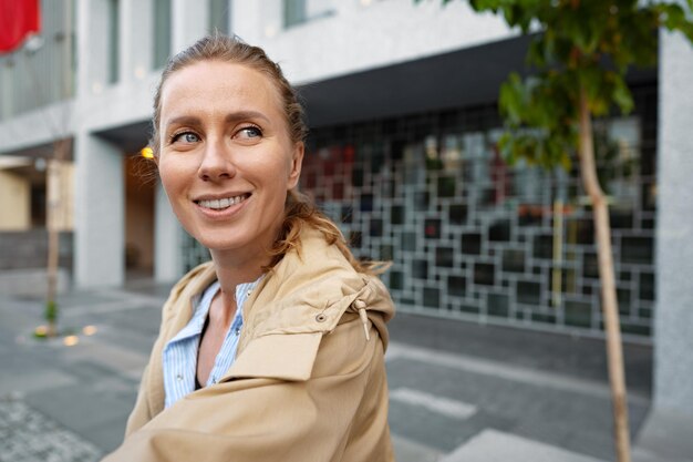 街でカメラにポーズをとる魅力的な若い女性のポートレート