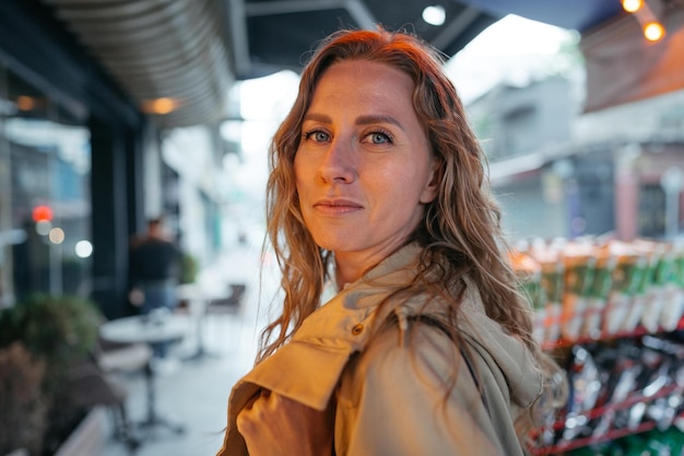 Ritratto di una giovane donna affascinante che posa per la macchina fotografica in città