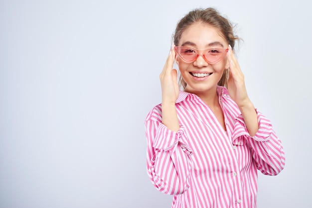 Portrait of a cheerful asian kazakh young woman in stylish glasses dressed casual smiling joyfully isolated on a white background