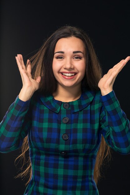 Portrait of cheerful attractive modern woman with long hair looking at camera and expressing positiv...