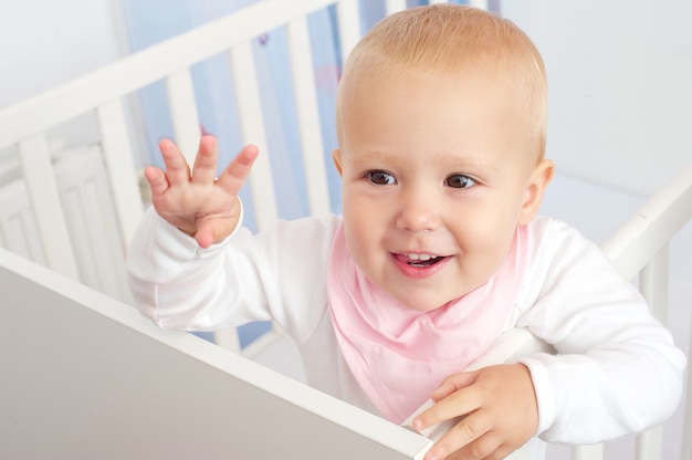 Portrait of a cheerful baby waving hello