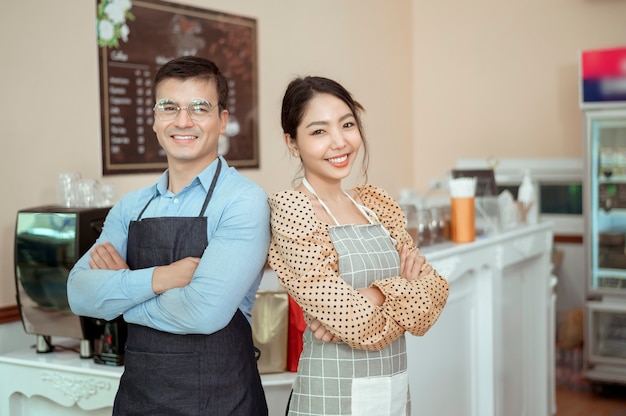 Portrait of cheerful baristas smiling in coffee shop