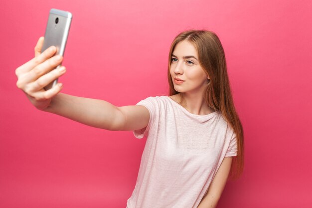 Portrait of cheerful beautiful girl, photographed, taking selfie