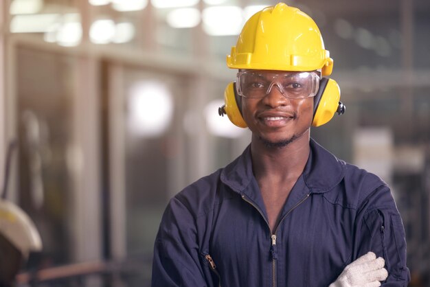 Photo portrait of cheerful black worker wearing protective headphones posing looking at camera