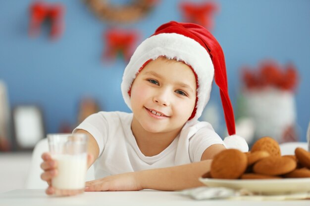 Ritratto di ragazzo allegro nella stanza di natale decorata, primo piano