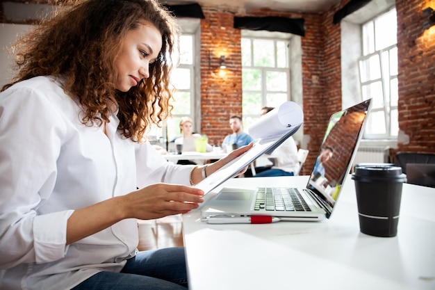 Portrait of cheerful business African-American lady working on laptop.