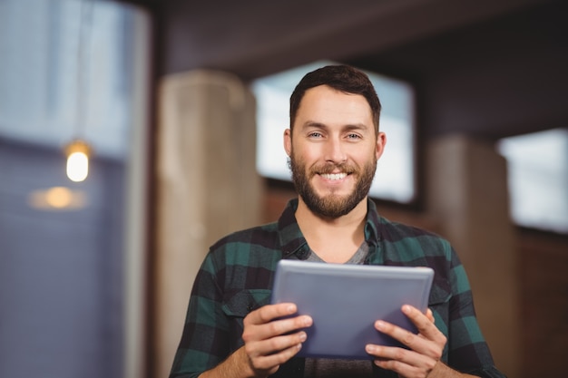 Portrait of cheerful businessman holding digital tablet  