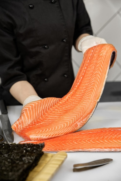 Portrait of cheerful chef standing with salmon fish Chef cutting fish and making sashimi