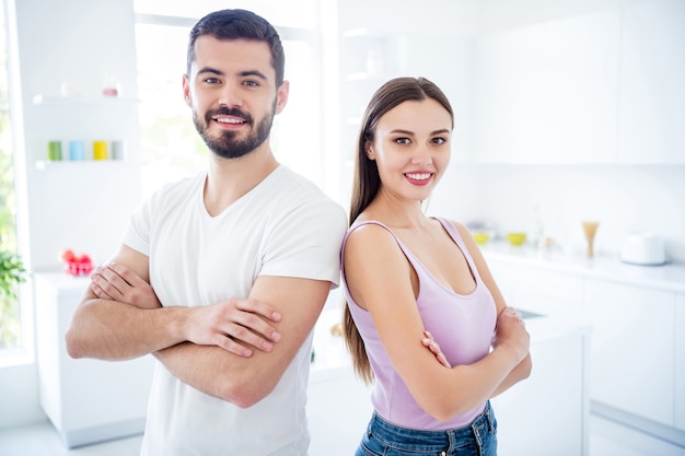 Portrait of cheerful cool smart independent couple cross hands