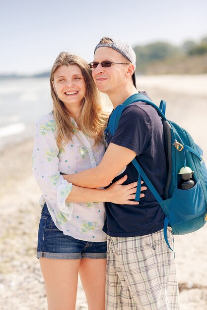 Portrait of a cheerful couple hugging on beach