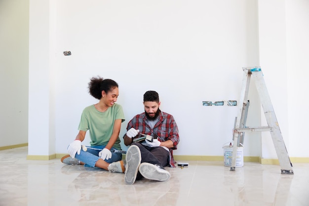 Portrait Cheerful couple young man and black woman smiling during renovation in new apartment