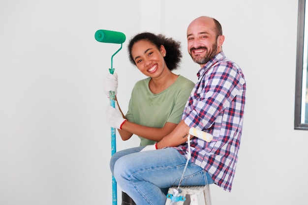 Portrait Cheerful couple young man and black woman smiling during renovation in new apartment