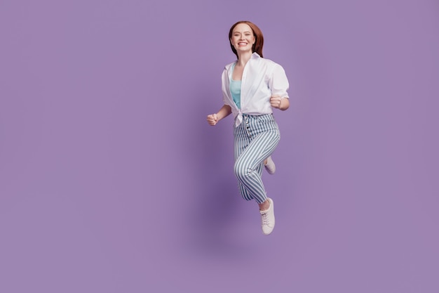 Portrait of cheerful crazy adorable lady jump run fast on violet background