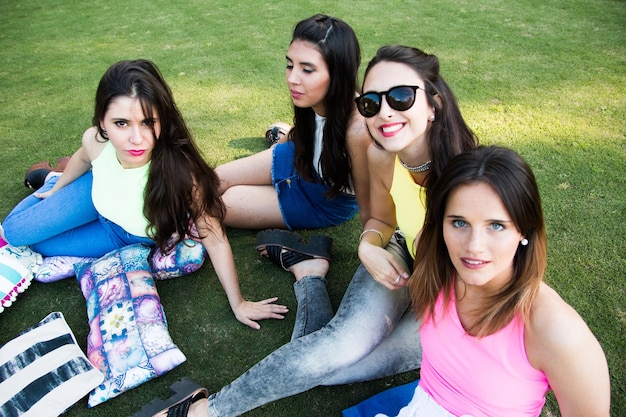 Photo portrait of cheerful female friends sitting on field