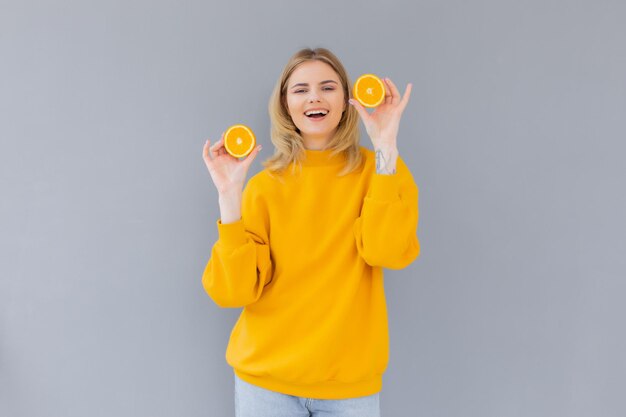 Portrait of a cheerful feminine girl with natural clear skin a girl with orange slices