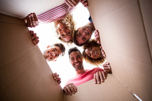 Portrait of cheerful friends seen through cardboard box