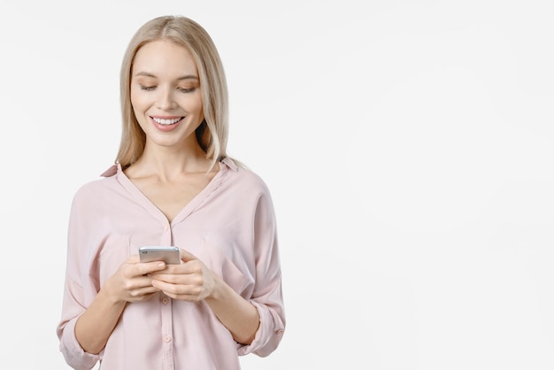 Portrait of cheerful girl holding mobile phone isolated over white background