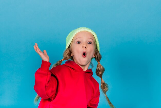 Portrait of a cheerful girl jumping and dancing against a studio background