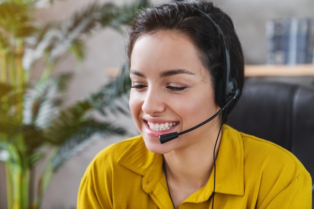 Portrait of cheerful girl operator manager talking on hot help line providing support service