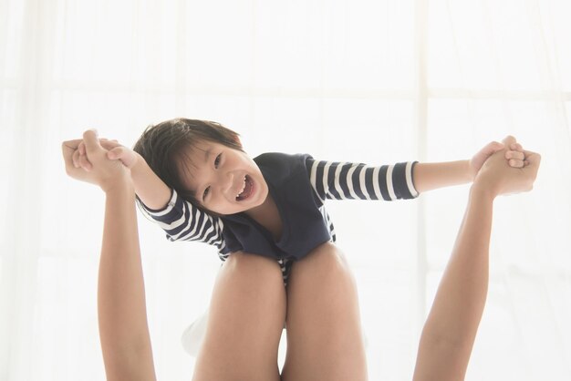 Portrait of cheerful girl playing with mother at home